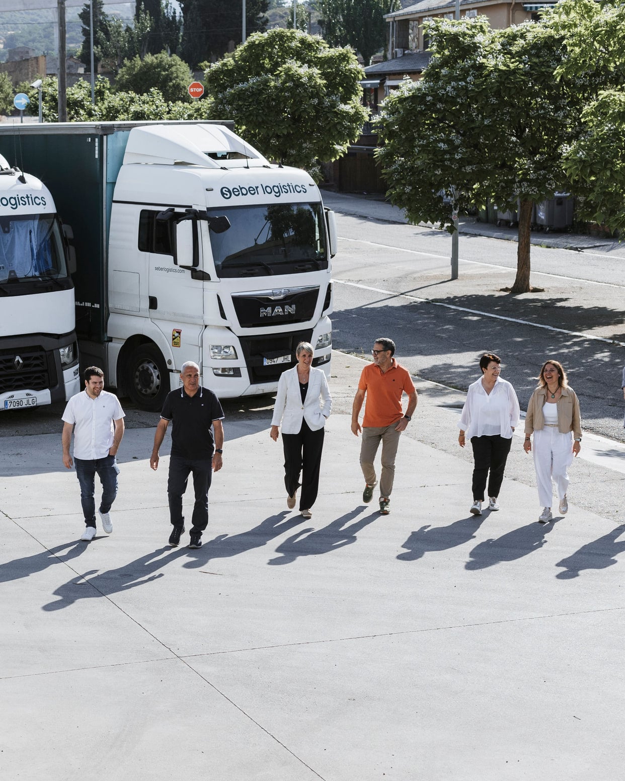 The Serra family at the Seber Logístics base, with trucks behind